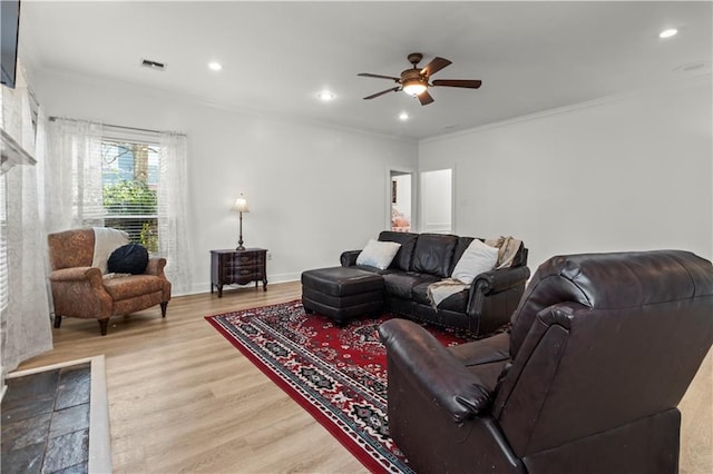 living room with ornamental molding, recessed lighting, visible vents, and wood finished floors