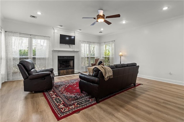 living room featuring ornamental molding, visible vents, and wood finished floors