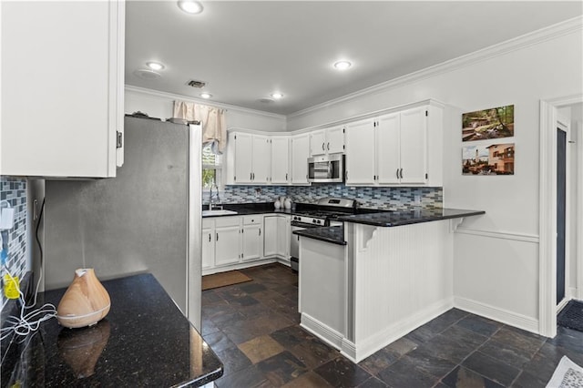 kitchen featuring tasteful backsplash, ornamental molding, a peninsula, stainless steel appliances, and a sink