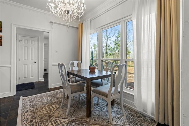 dining space featuring baseboards, ornamental molding, a wealth of natural light, and an inviting chandelier