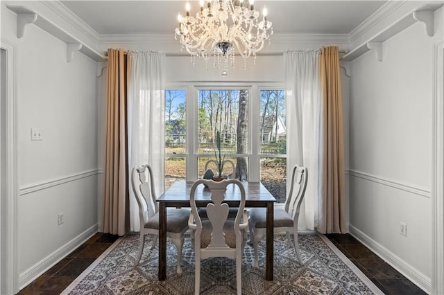 dining space with a notable chandelier, baseboards, and crown molding