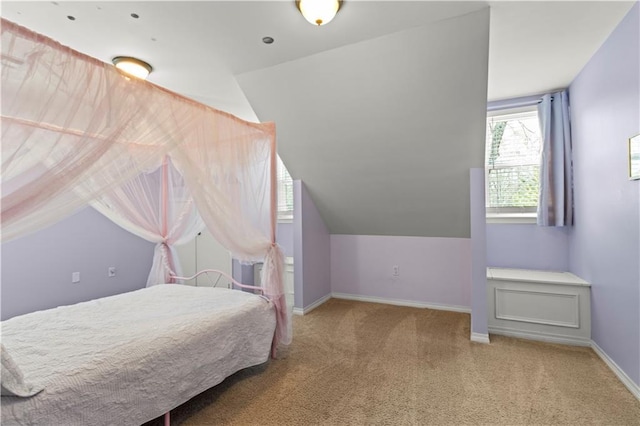 carpeted bedroom with vaulted ceiling and baseboards