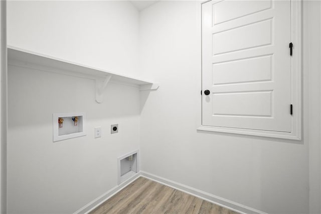 clothes washing area with hookup for a washing machine, hookup for an electric dryer, laundry area, wood finished floors, and baseboards