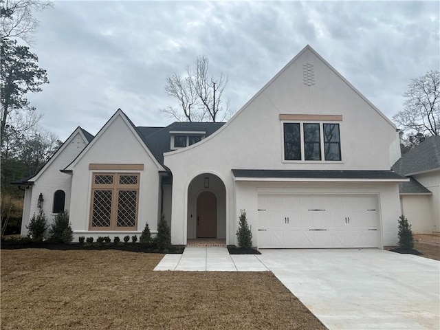 view of front facade with a garage, concrete driveway, and stucco siding