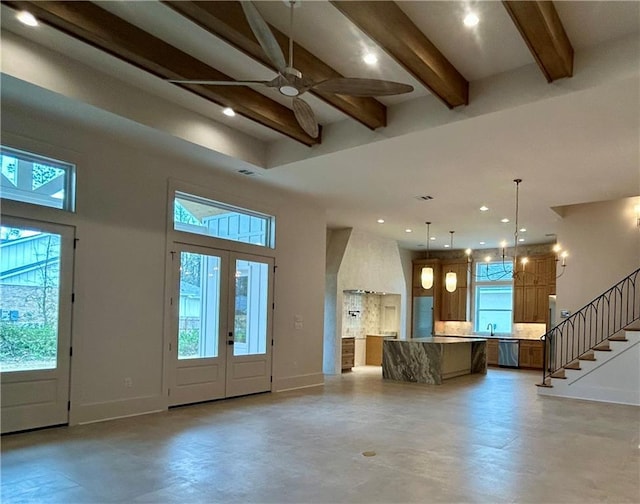 foyer entrance with beam ceiling, a high ceiling, stairway, and baseboards