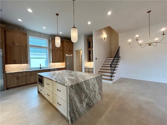 kitchen featuring light stone counters, recessed lighting, decorative backsplash, a kitchen island, and built in appliances