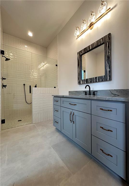 full bath with a stall shower and vanity