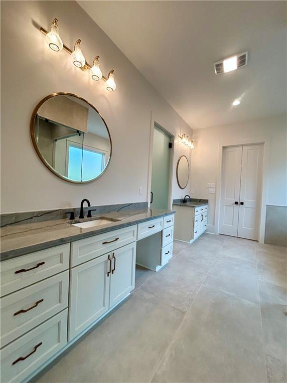 full bathroom featuring concrete flooring, vanity, and visible vents