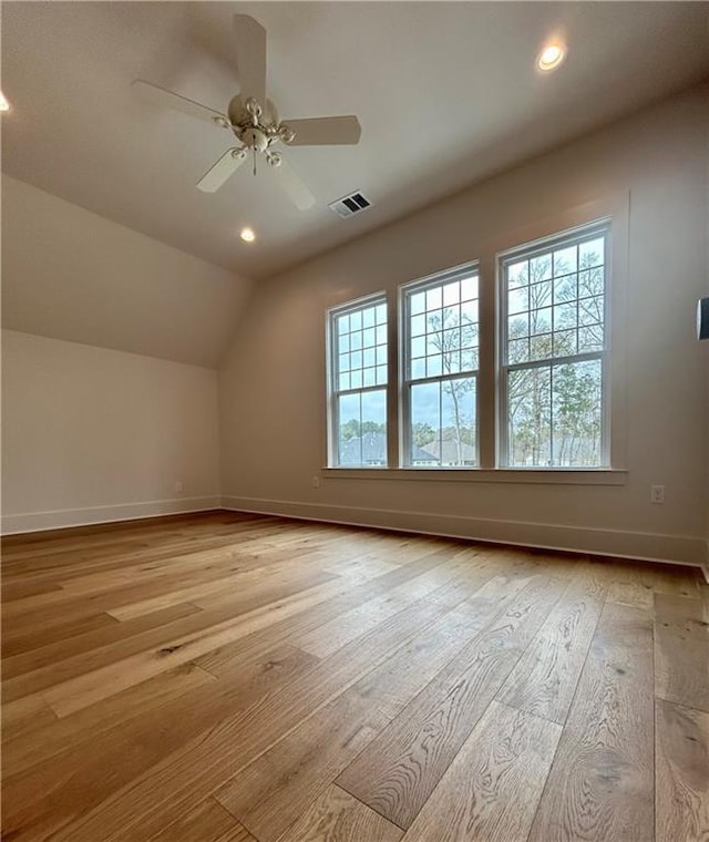 bonus room featuring light wood finished floors, visible vents, vaulted ceiling, and a wealth of natural light