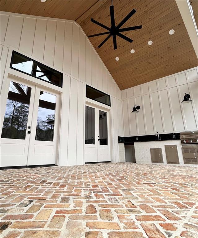 view of patio with a ceiling fan, grilling area, exterior kitchen, and french doors