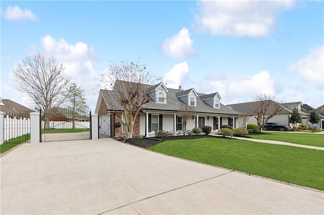 cape cod home featuring brick siding, fence, concrete driveway, a gate, and a front yard