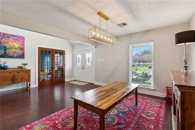 dining area with baseboards, visible vents, dark wood-style floors, a textured ceiling, and french doors