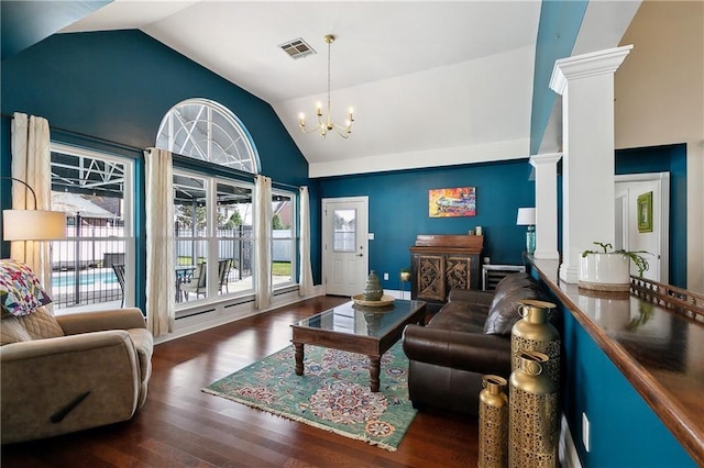 living room featuring a healthy amount of sunlight, decorative columns, a notable chandelier, and wood finished floors