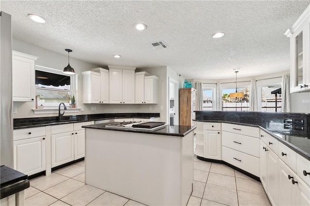 kitchen with white cabinetry, stainless steel gas stovetop, and visible vents