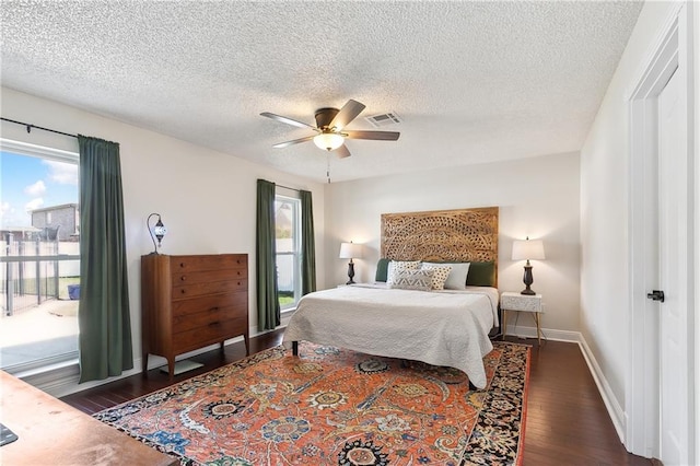 bedroom with baseboards, visible vents, a ceiling fan, dark wood-style floors, and a textured ceiling