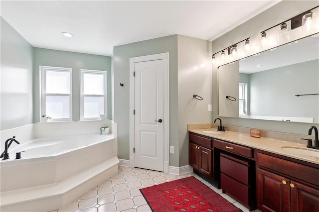 bathroom featuring plenty of natural light, a garden tub, and a sink