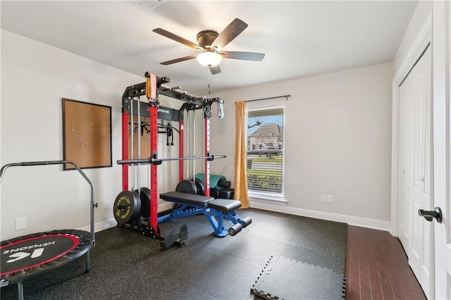 exercise area with ceiling fan and baseboards