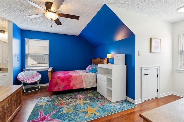 bedroom with a textured ceiling, vaulted ceiling, and wood finished floors