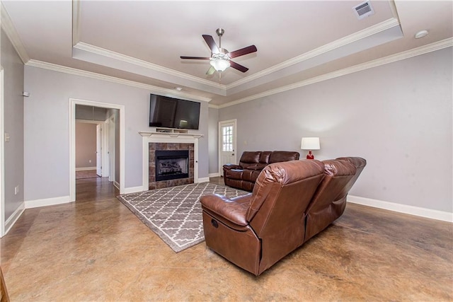 living area featuring a tile fireplace, a raised ceiling, visible vents, and baseboards