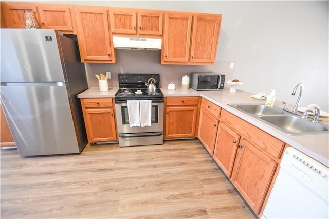 kitchen featuring light countertops, appliances with stainless steel finishes, a sink, and under cabinet range hood