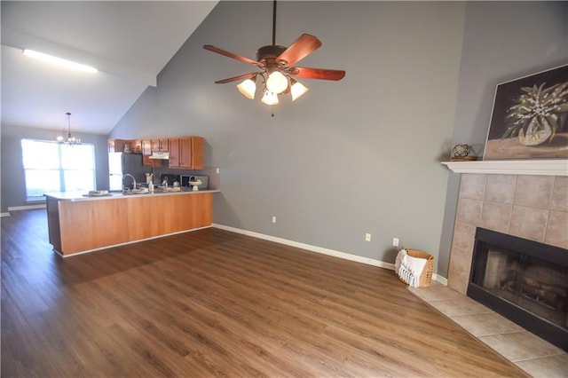14249 Woodlands Dr Unit 22, Hammond, LA 70401 - living area with baseboards, dark wood finished floors, a tiled fireplace, and ceiling fan with notable chandelier