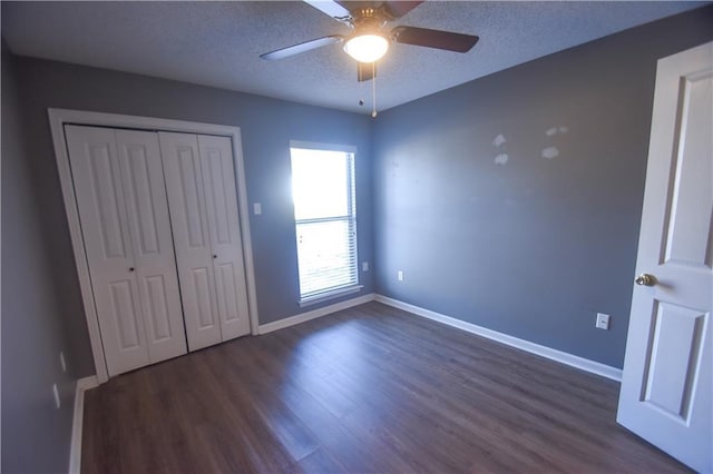 14249 Woodlands Dr Unit 22, Hammond, LA 70401 - unfurnished bedroom with dark wood-style flooring, a closet, ceiling fan, a textured ceiling, and baseboards