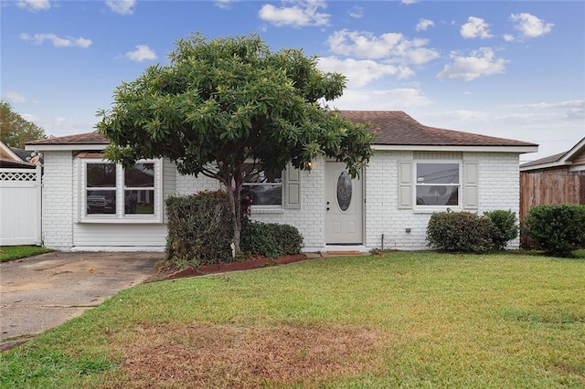 view of front of house featuring fence, a front lawn, and brick siding