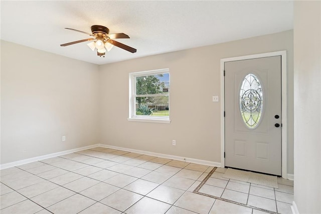 entryway with light tile patterned floors, baseboards, and a ceiling fan