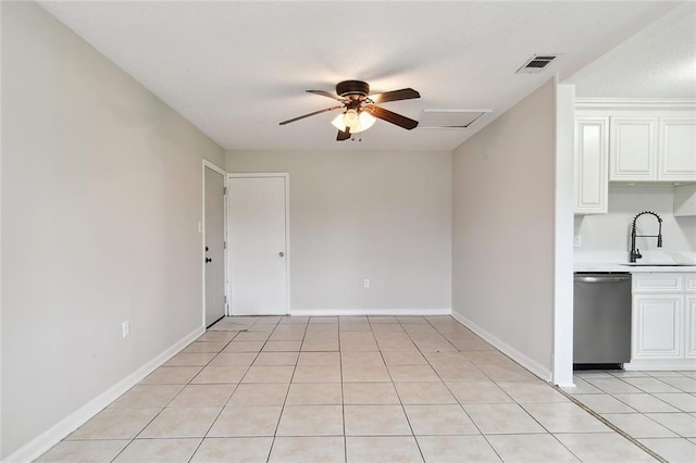 spare room with light tile patterned floors, visible vents, ceiling fan, a sink, and baseboards