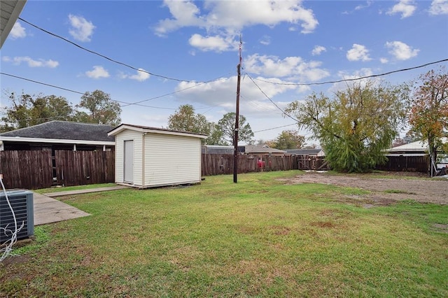 view of yard with cooling unit, a fenced backyard, an outdoor structure, and a shed