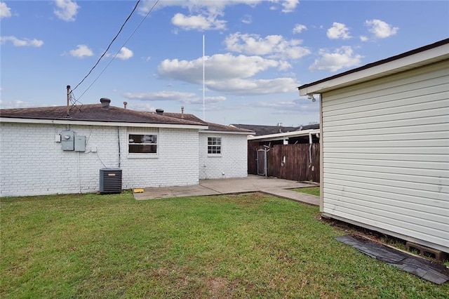 rear view of house featuring a yard, brick siding, a patio area, and fence