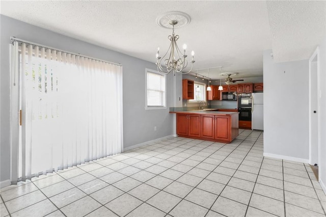 kitchen with a sink, a peninsula, black appliances, and a textured ceiling