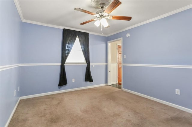 carpeted spare room featuring ceiling fan, ornamental molding, and baseboards