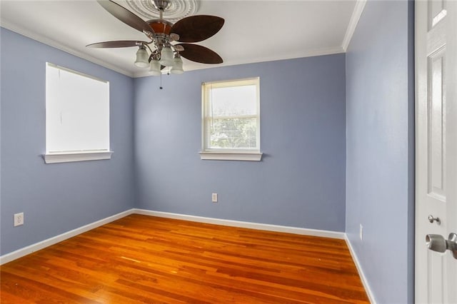 unfurnished room with ceiling fan, crown molding, baseboards, and wood finished floors