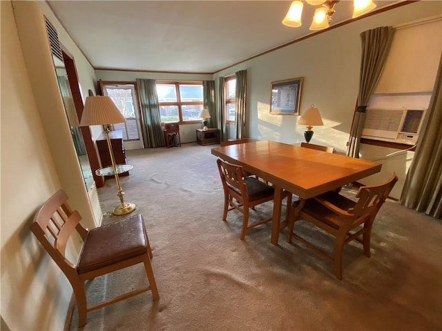 dining area with carpet floors, ornamental molding, and a notable chandelier