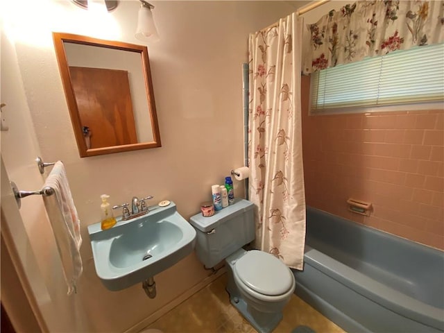 bathroom with a sink, toilet, and shower / tub combo with curtain