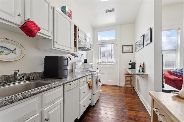 kitchen featuring white appliances, dark wood-type flooring, a sink, visible vents, and white cabinetry