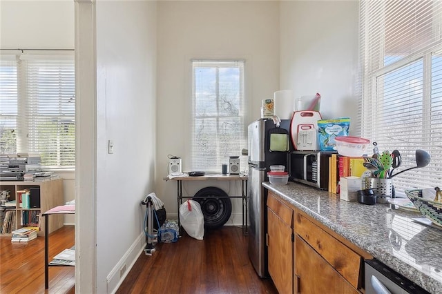 interior space featuring baseboards, dark wood-style flooring, and a healthy amount of sunlight