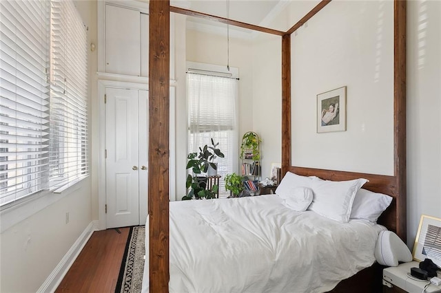 bedroom with baseboards and wood finished floors