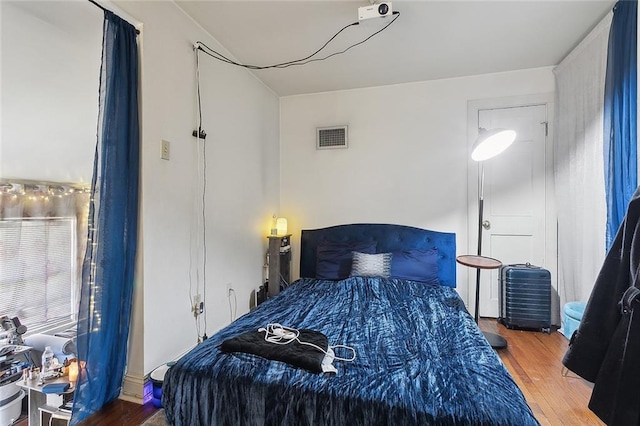 bedroom with visible vents and wood finished floors