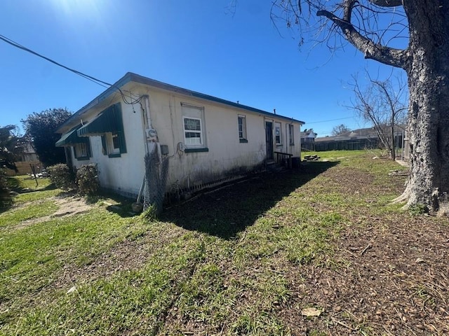 view of home's exterior featuring fence and a lawn