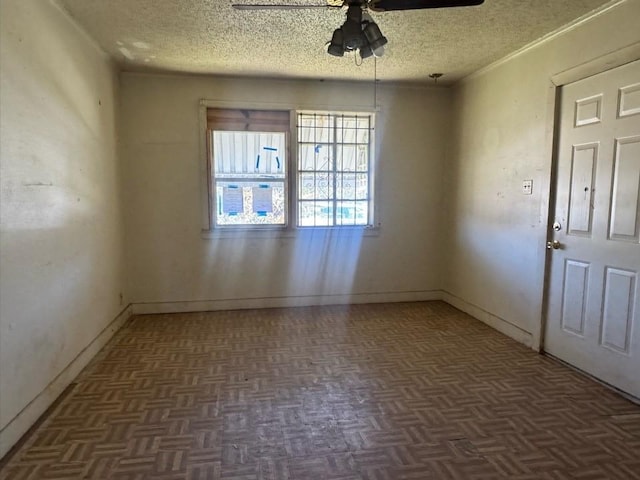 unfurnished room with ceiling fan, a textured ceiling, and baseboards