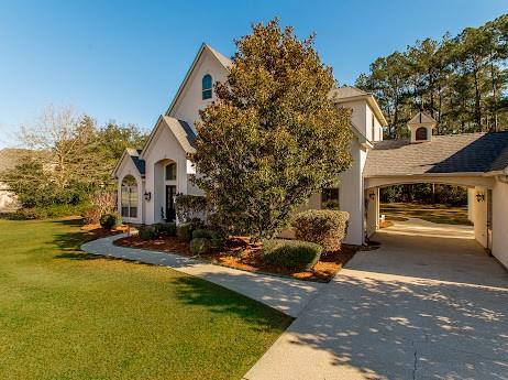 view of front of home featuring stucco siding, concrete driveway, and a front yard