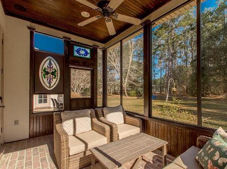 sunroom featuring a healthy amount of sunlight, wooden ceiling, and ceiling fan