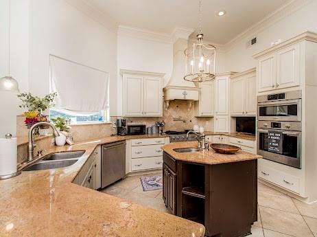 kitchen featuring stainless steel appliances, tasteful backsplash, a sink, and crown molding