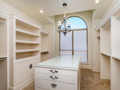 spacious closet featuring an inviting chandelier