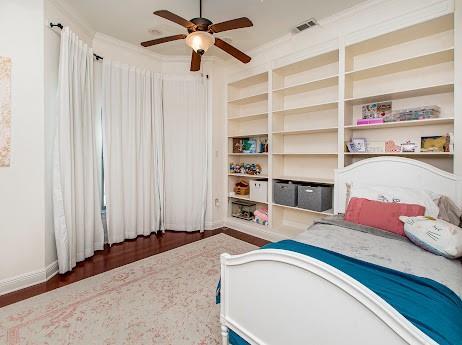 bedroom featuring visible vents, ceiling fan, baseboards, and wood finished floors