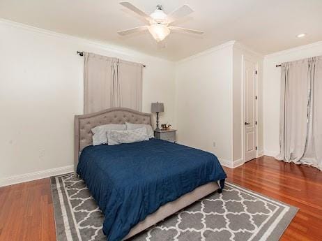 bedroom featuring ornamental molding, wood finished floors, a ceiling fan, and baseboards