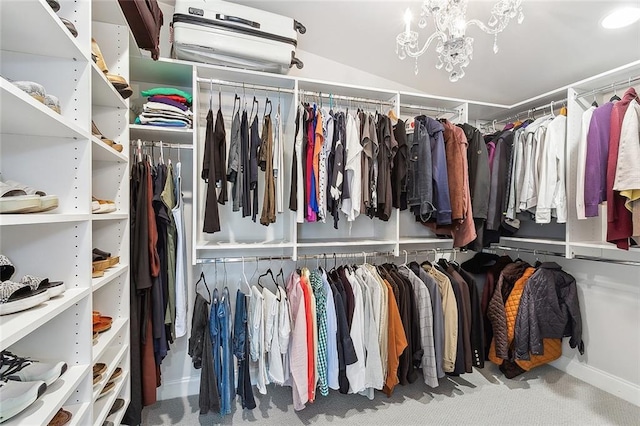 walk in closet featuring a chandelier and carpet flooring