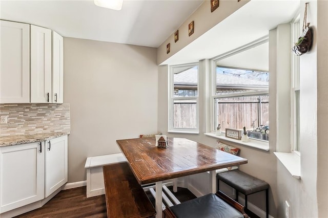 dining room featuring dark wood finished floors and baseboards